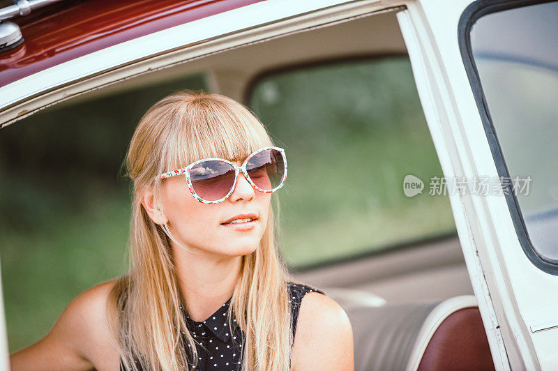 年轻女子坐在老爷车里寻找正确的方向