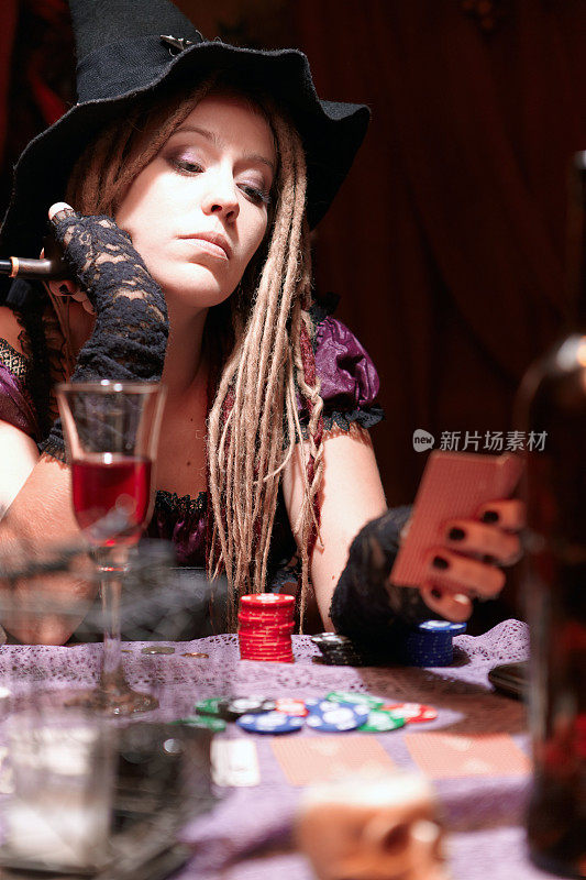万圣节的赌场。拿着卡片抽着烟斗的女巫。