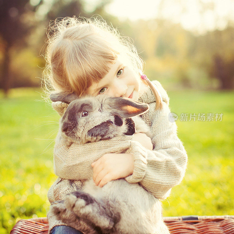 小女孩拥抱一只兔子