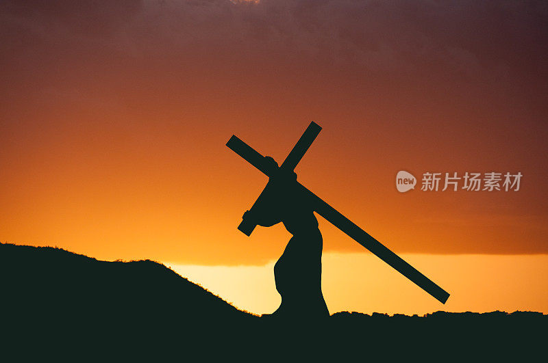 基督在日落中背着他的十字架。