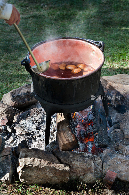 在篝火上放壶热苹果酒