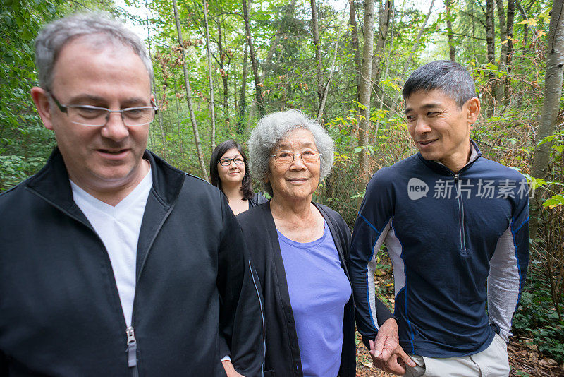 年长的亚洲祖母与儿子，女儿，家人在森林里散步