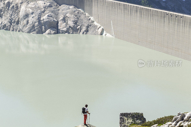 靠近大坝和高山湖泊的徒步旅行者