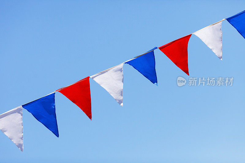 红色、白色和蓝色的旗帜在蓝天的背景下