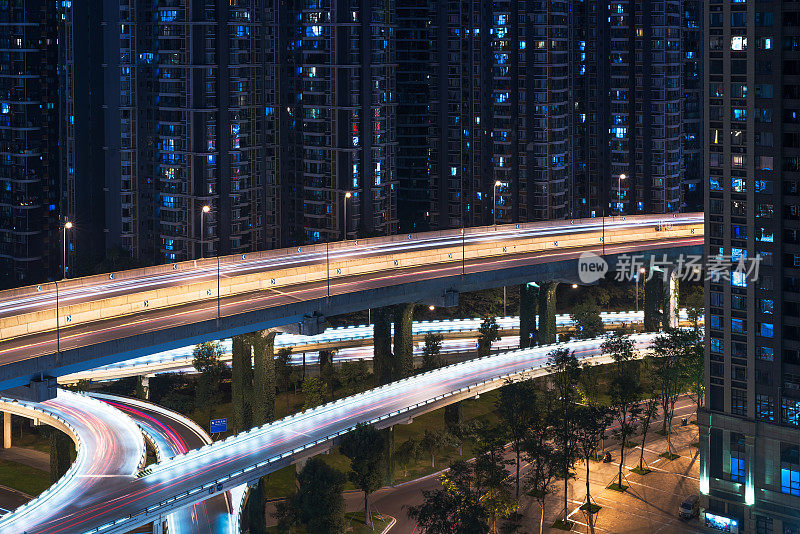 在中国成都，夜间的空中道路穿过住宅楼