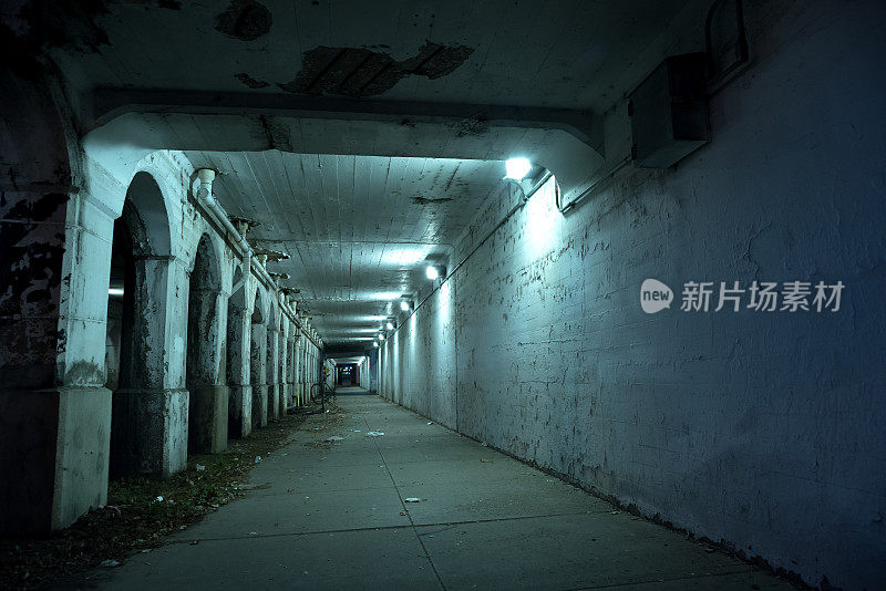 粗糙黑暗的芝加哥城市街道与工业火车桥高架桥隧道在晚上。