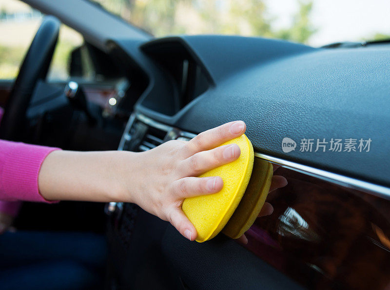 女人用清洁海绵手工清洗汽车内部
