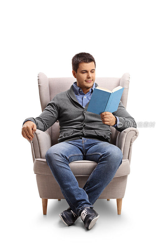 一个年轻人坐在扶手椅上看书