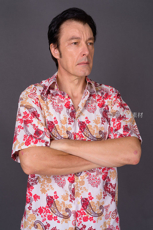 成熟英俊的游客男子穿着夏威夷衬衫准备在灰色背景下度假