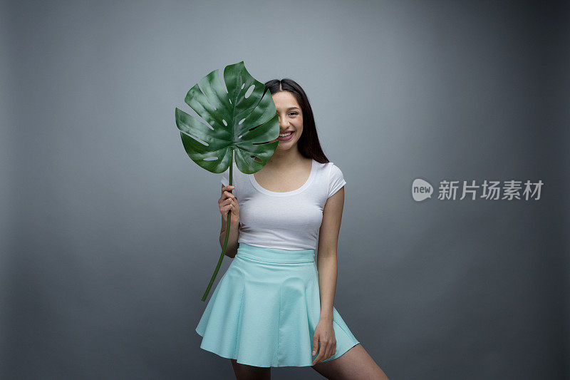 美丽的年轻女子拿着一片叶子