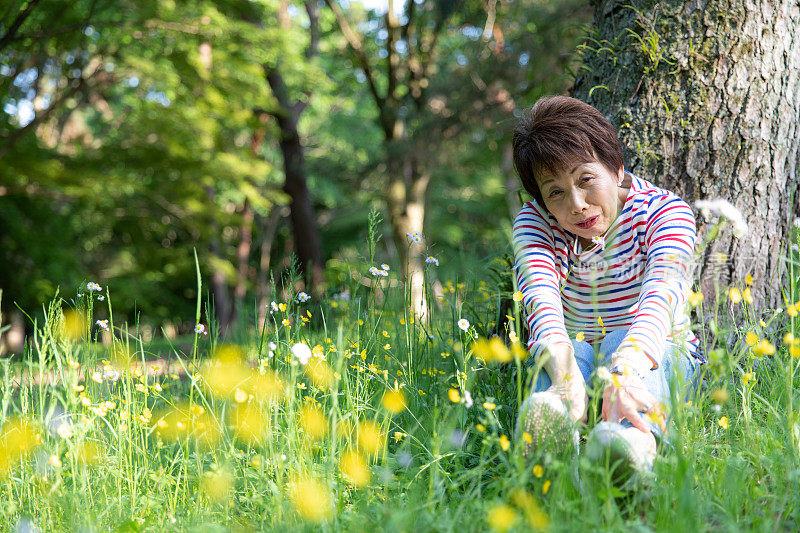 老年妇女在花园里享受早春