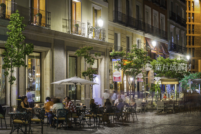 马德里人在人行道上的咖啡馆、酒吧、餐馆放松西班牙之夜