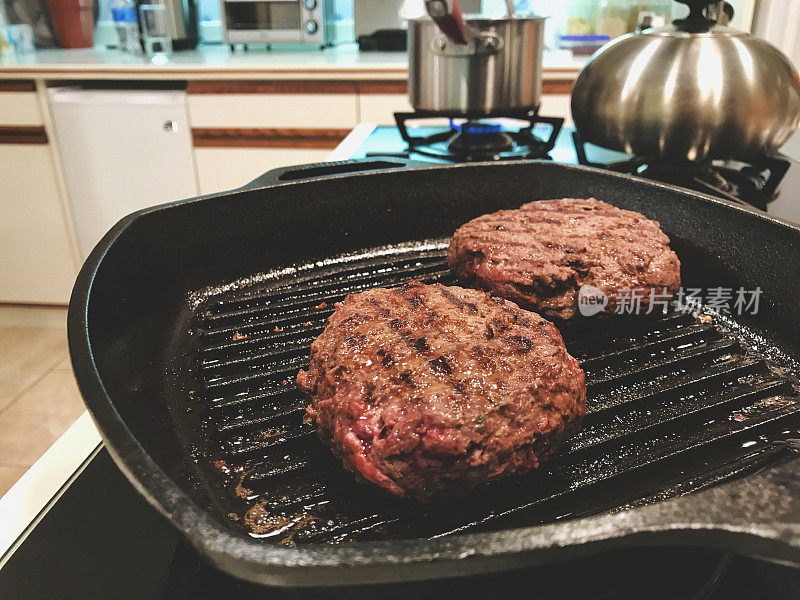 汉堡麋鹿汉堡肉饼在炉子上冷却在平底锅