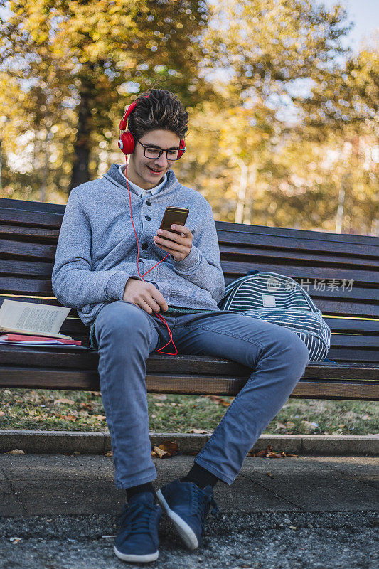 十几岁的男孩在上学前玩手机游戏