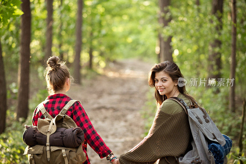 两个时髦女孩在森林里散步