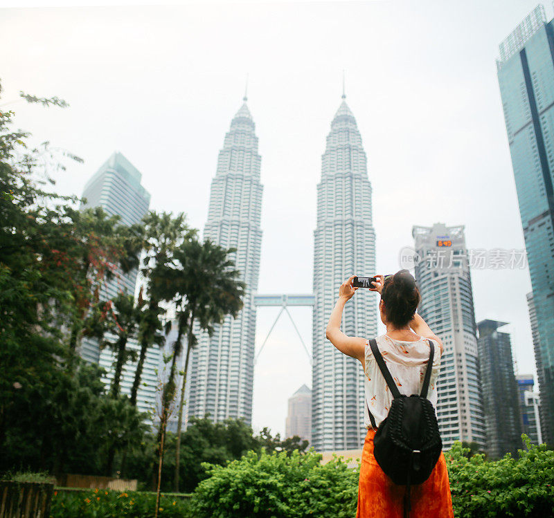 后视图的一个单独旅行者的女人在吉隆坡，马来西亚公共公园