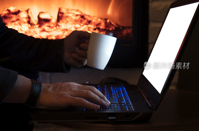 男人在壁炉旁用笔记本电脑聊天喝咖啡