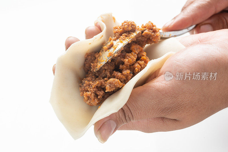 女性正在准备牛肉肉馅卷饼(肉饼)