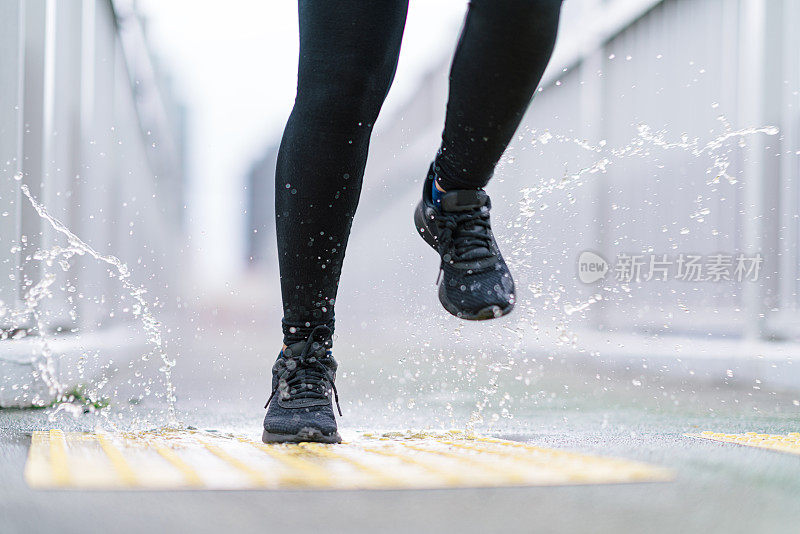 近距离照片的腿，不认识的人在雨天跑步