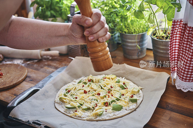 准备牛油果素食披萨配白干酪和辣椒