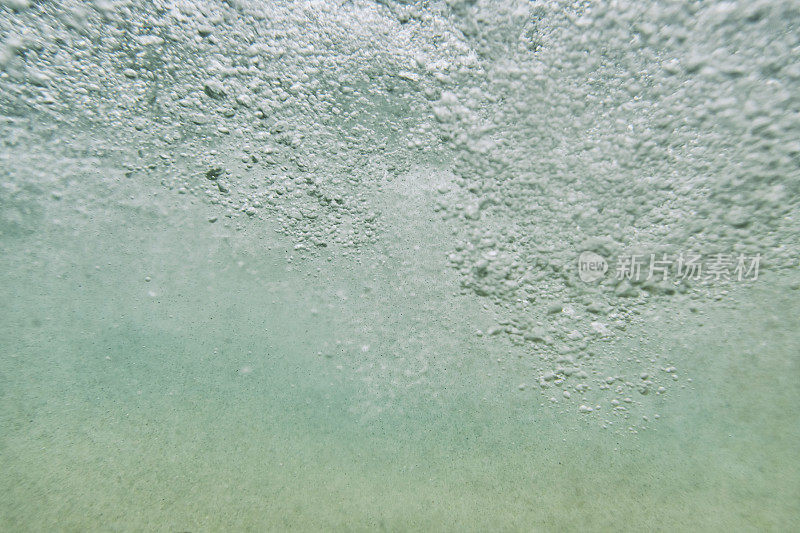 模糊的海底气泡从一个波浪通过头顶。