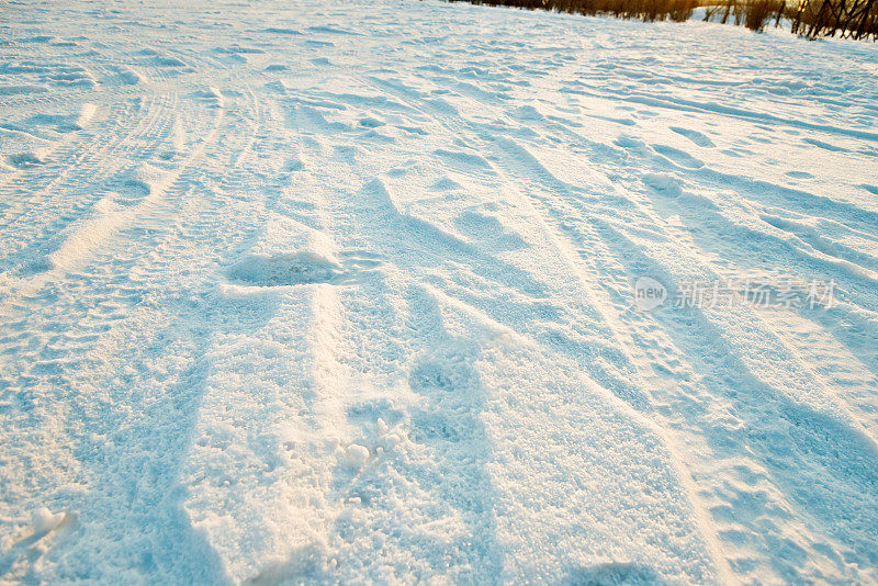 雪地上的车胎痕迹和脚印