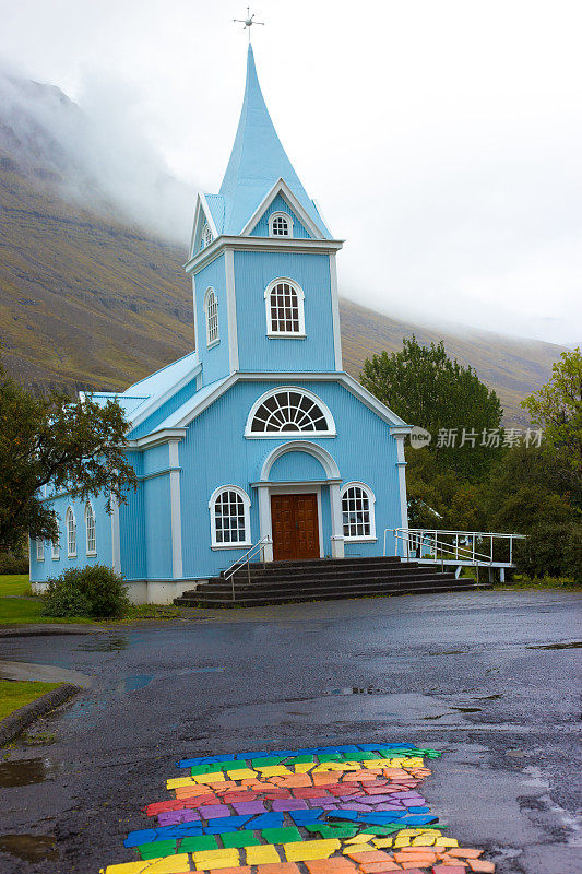 Seyðisfjörður，冰岛:雨中的蓝色教堂和彩虹街