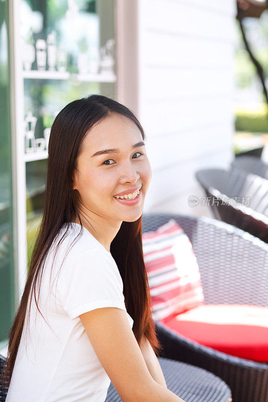 一个年轻的泰国女人在咖啡馆外