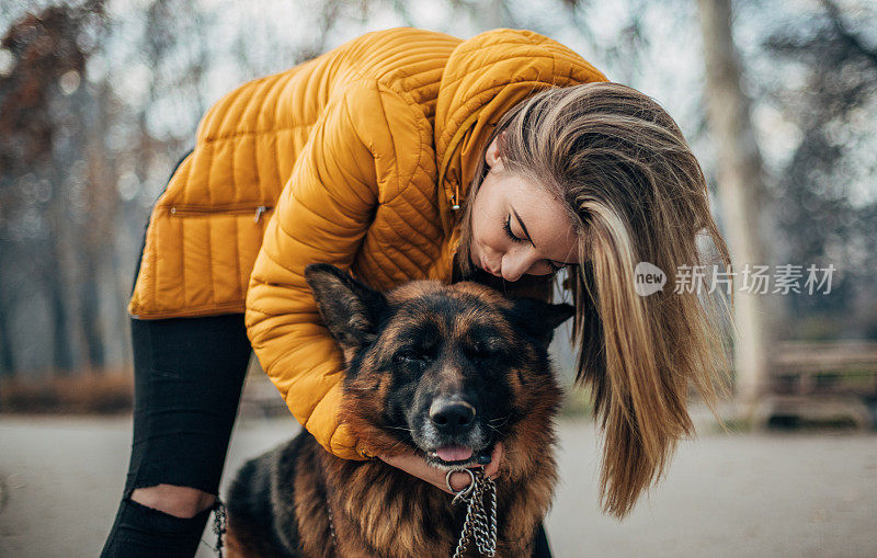 年轻女子和德国牧羊犬在公园里玩