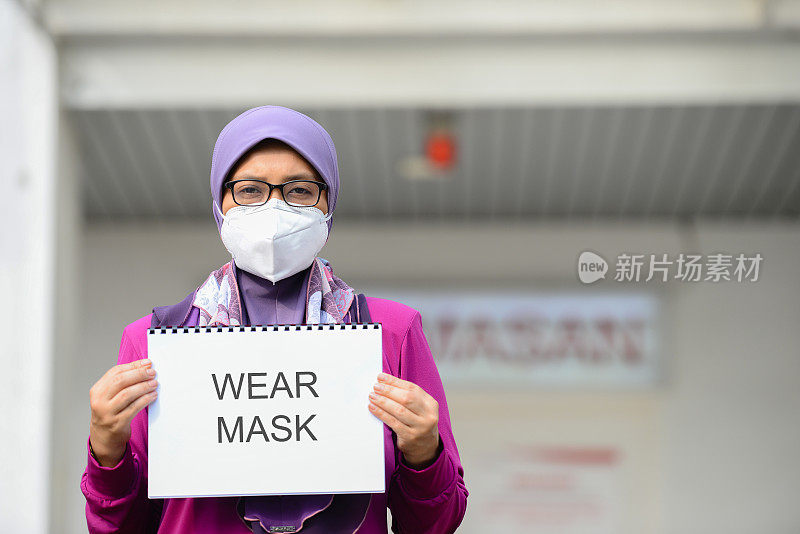 马来西亚医院前，医护人员戴着口罩举着标语