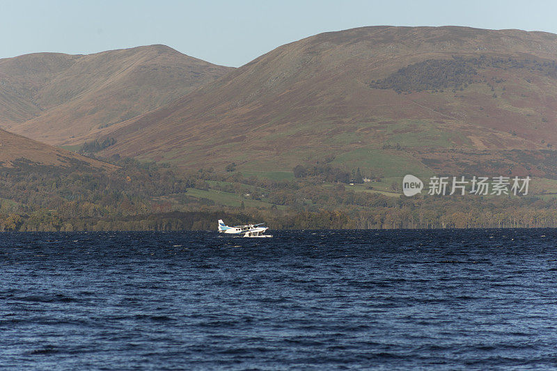 一架水上飞机在英国苏格兰附近的洛蒙德湖公园的湖岸起飞