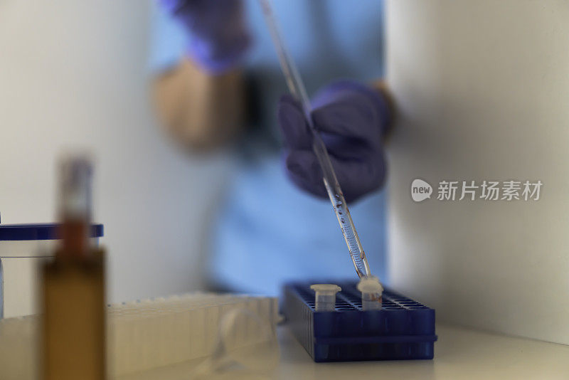 近距离拍摄的人在实验室工作与生物危害物质保持距离，而实验