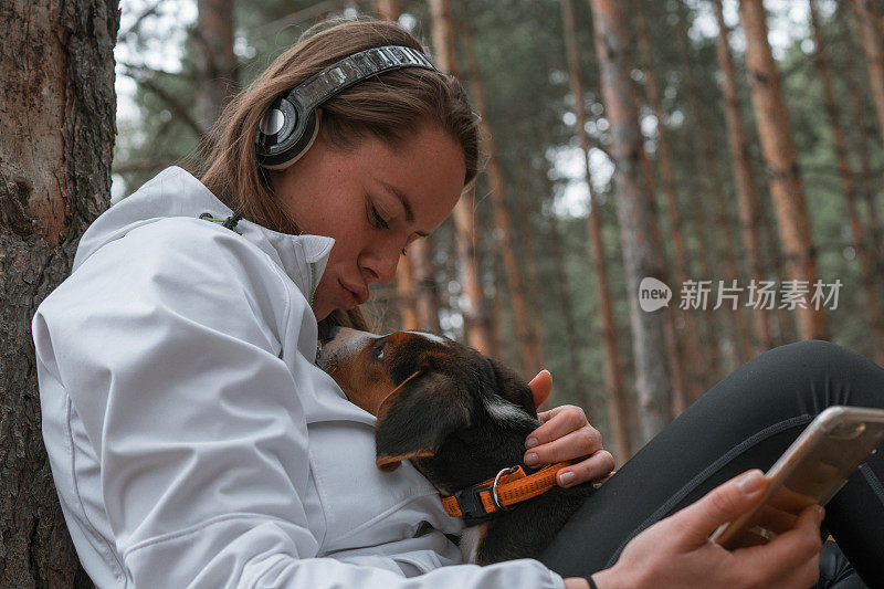 年轻的运动女性和她最好的朋友在大自然中放松