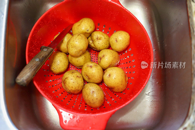 育空黄金有机土豆在厨房水槽的滤锅里
