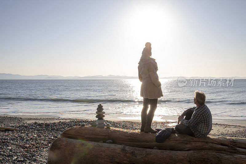 日出时分，成熟的夫妇在海滩上放松