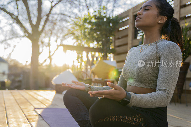 美丽的中东女性在后院做瑜伽