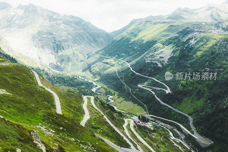 在阳光明媚的夏日里，瑞士弯弯曲曲的山路风景一览无遗