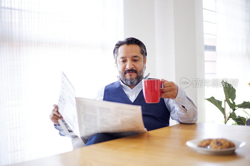 男人在家里喝茶看报纸