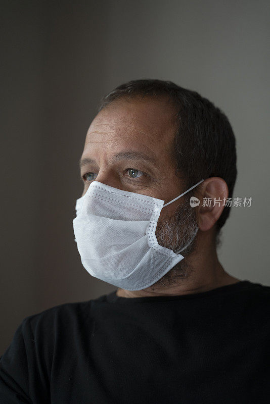 冠状病毒爆发期间，戴口罩居家隔离的男子
