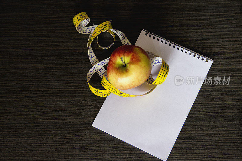 饮食的概念。苹果和卷尺。