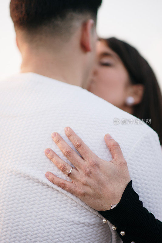 戴着订婚戒指的女人亲吻她的未婚夫