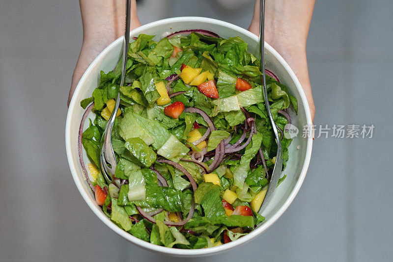 女人拿着新鲜水果和蔬菜，健康饮食库存照片