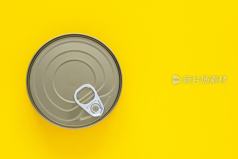 黄色背景上的圆形锡罐。本空间