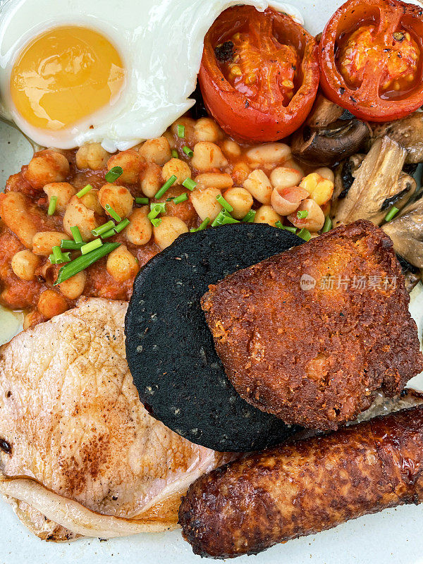 全帧图像盘全英式早餐，单面煎蛋，香肠，培根，黑布丁，土豆，蘑菇，番茄和烤豆，高架视野