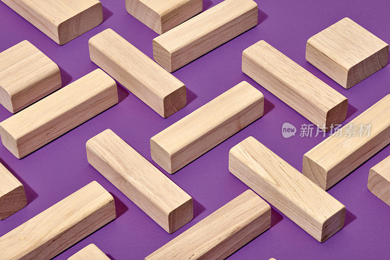 长方形的木块以几何形状排列在紫色的背景上