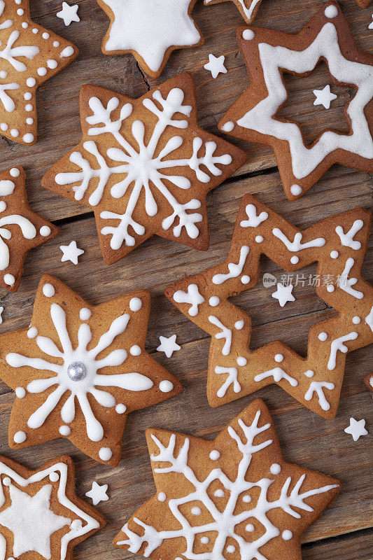 姜饼圣诞姜饼饼干星形白色糖衣全框在棕色木桌上。