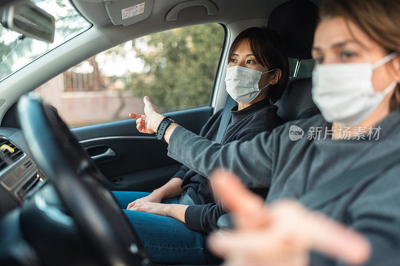 驾校的女教师正在教年轻女子如何开车。