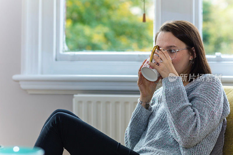 年轻自信的女人正在看电视