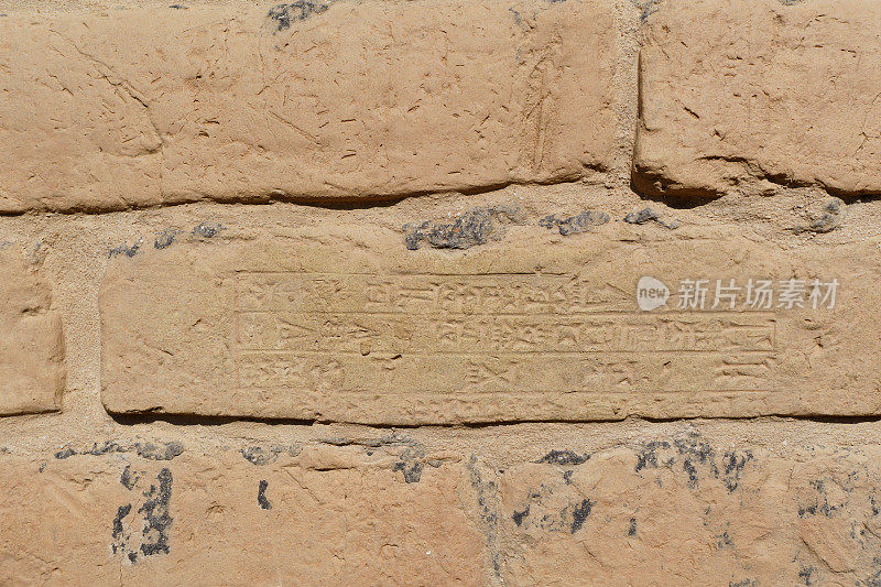 伊拉克，巴比伦——2023年2月11日:一块刻有巴比伦楔形文字的墙砖的近距离特写。