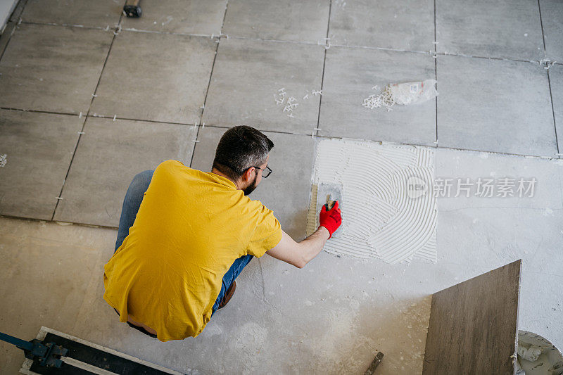 工人把新瓷砖铺在地板上